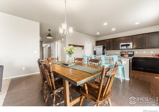6747 Grainery Rd, Timnath, CO 80547 - dining space featuring dark wood-style flooring, recessed lighting, baseboards, and a chandelier