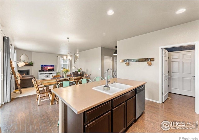 6747 Grainery Rd, Timnath, CO 80547 - kitchen featuring dishwasher, a sink, light wood-type flooring, dark brown cabinetry, and light countertops