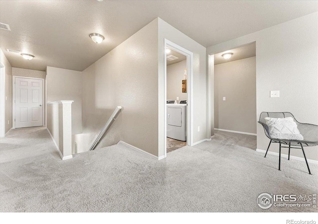 6747 Grainery Rd, Timnath, CO 80547 - hall featuring an upstairs landing, separate washer and dryer, carpet flooring, baseboards, and a textured ceiling