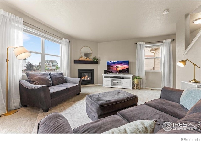 6747 Grainery Rd, Timnath, CO 80547 - living area with a glass covered fireplace, healthy amount of natural light, and light carpet
