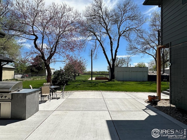 view of patio with fence, outdoor dining area, area for grilling, an outdoor kitchen, and an outbuilding