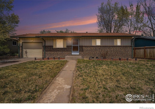 single story home featuring concrete driveway, brick siding, a front yard, and a garage
