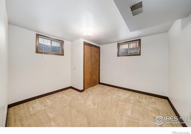 interior space with light carpet, visible vents, and baseboards