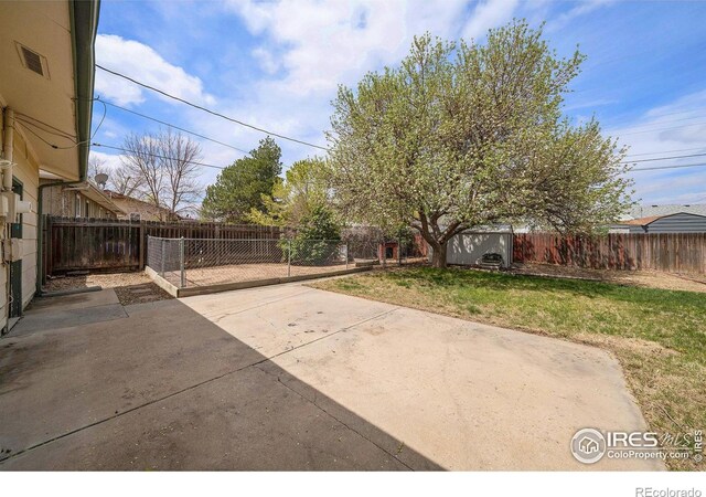 exterior space with a storage shed, a fenced backyard, a patio, and an outdoor structure