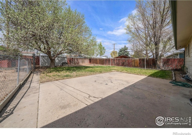 view of patio / terrace featuring an outbuilding, a shed, and a fenced backyard