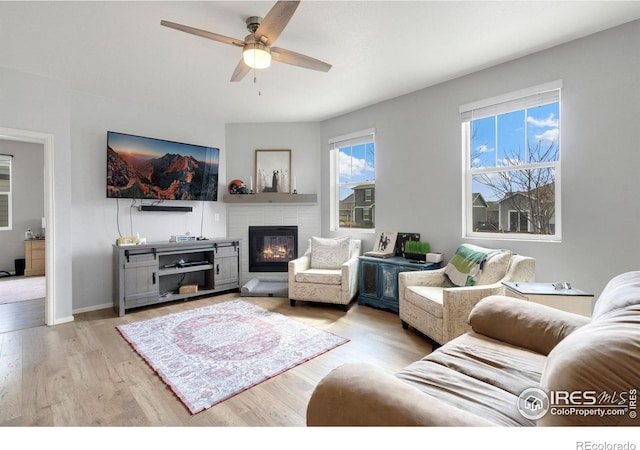 2000 Rose Petal Dr, Windsor, CO 80550 - living area with a ceiling fan, wood finished floors, a glass covered fireplace, and baseboards