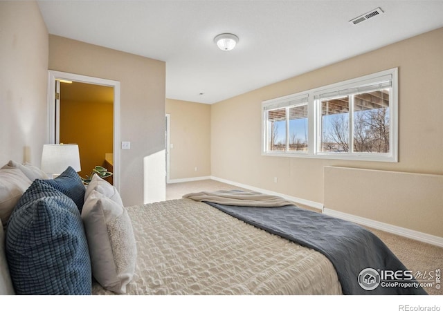 carpeted bedroom with baseboards and visible vents