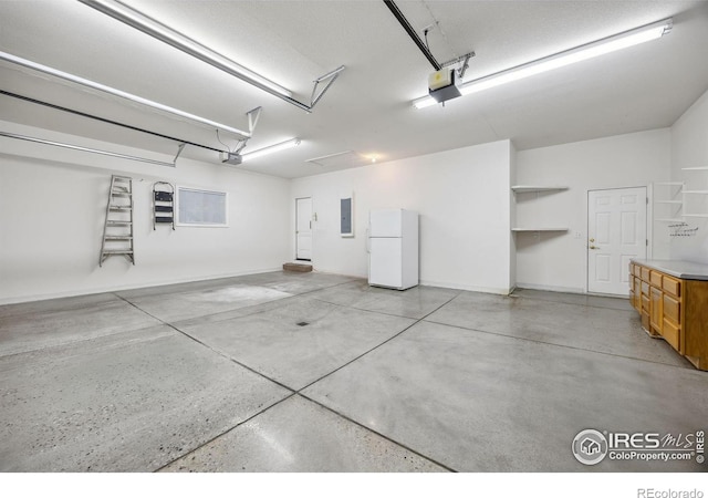 garage featuring baseboards, freestanding refrigerator, a garage door opener, and electric panel