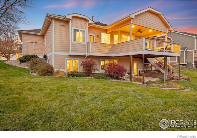back of house at dusk featuring a wooden deck, central air condition unit, a yard, a patio, and stairs