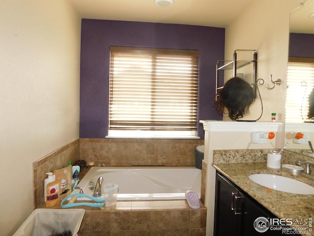 full bathroom featuring plenty of natural light, vanity, and a garden tub