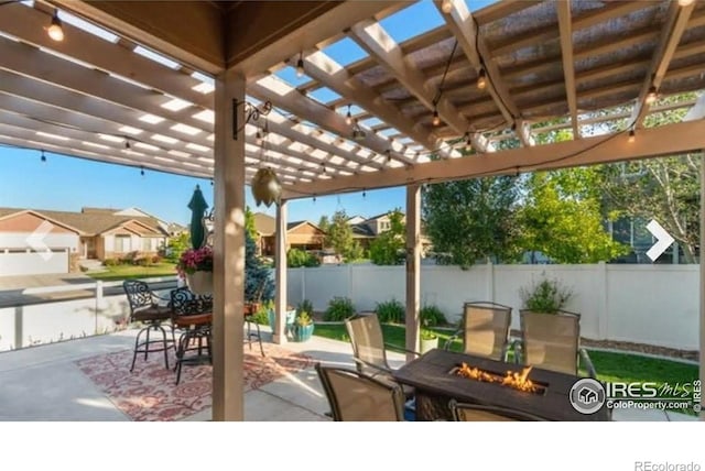 view of patio with an outdoor fire pit, fence, a pergola, and a residential view