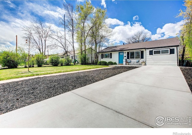 ranch-style house with concrete driveway and a front yard