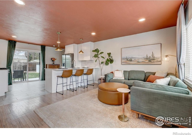 living area featuring light wood-style floors and recessed lighting