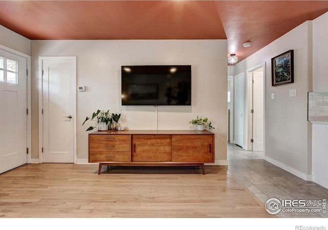 foyer with baseboards and light wood-style flooring