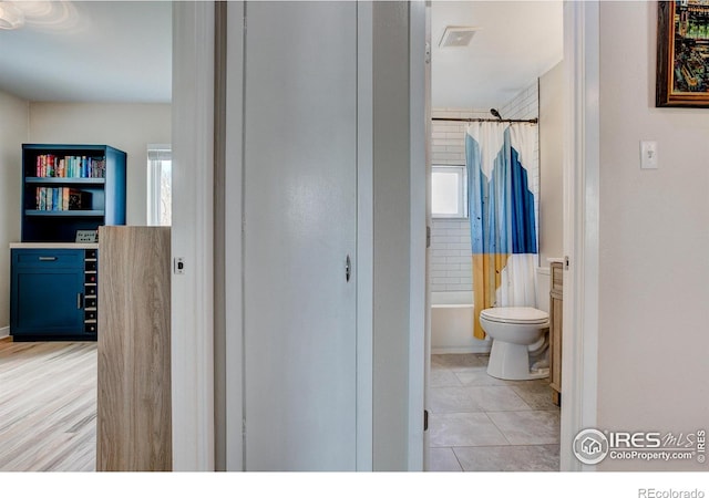 bathroom featuring toilet, tile patterned floors, visible vents, and plenty of natural light
