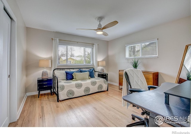 bedroom featuring baseboards, ceiling fan, a closet, and wood finished floors