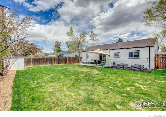 view of yard featuring an outdoor structure, a fenced backyard, a shed, an outdoor living space, and a patio area