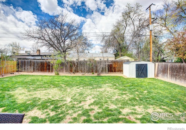 view of yard featuring an outbuilding, a fenced backyard, and a storage unit