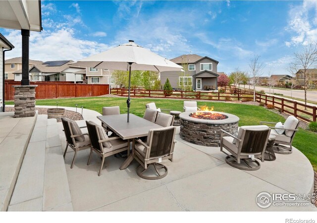 2121 Covered Bridge Pkwy, Windsor, CO 80550 - view of patio featuring a residential view, a fire pit, and a fenced backyard