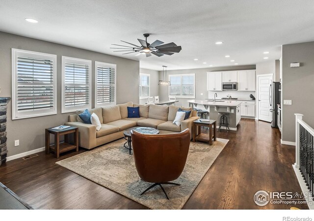 2121 Covered Bridge Pkwy, Windsor, CO 80550 - living area featuring baseboards, ceiling fan, dark wood-style floors, and visible vents
