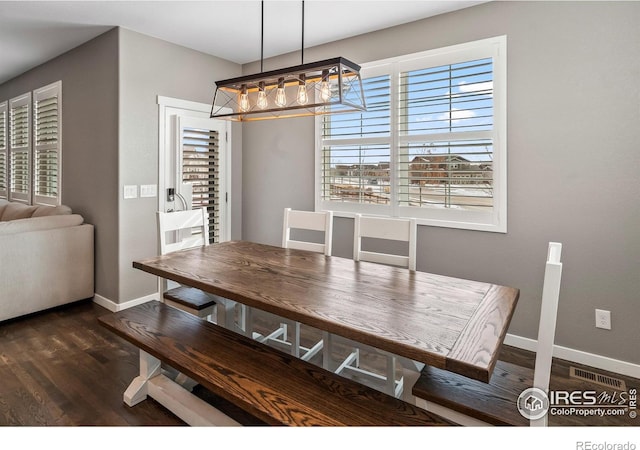 2121 Covered Bridge Pkwy, Windsor, CO 80550 - dining space with baseboards, visible vents, a notable chandelier, and dark wood-type flooring