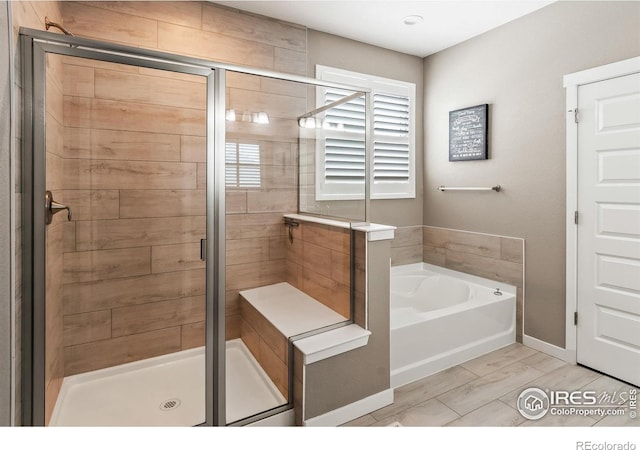 2121 Covered Bridge Pkwy, Windsor, CO 80550 - bathroom featuring baseboards, a bath, and a stall shower