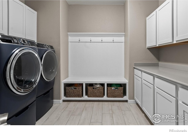 2121 Covered Bridge Pkwy, Windsor, CO 80550 - washroom featuring baseboards, light wood-type flooring, cabinet space, and washing machine and clothes dryer