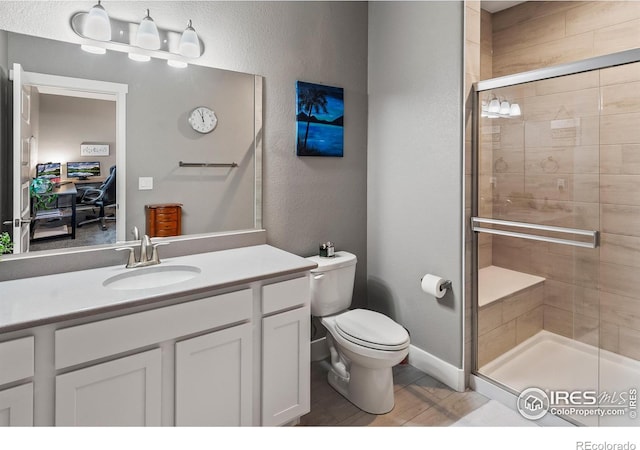 2121 Covered Bridge Pkwy, Windsor, CO 80550 - full bathroom featuring a textured wall, vanity, toilet, baseboards, and a stall shower