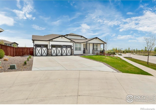 2121 Covered Bridge Pkwy, Windsor, CO 80550 - modern farmhouse with fence, driveway, stone siding, and a garage