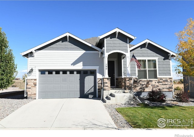craftsman-style home featuring a garage, stone siding, and concrete driveway
