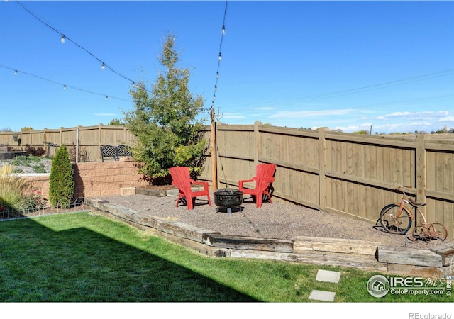 view of jungle gym featuring a yard, a fenced backyard, and an outdoor fire pit