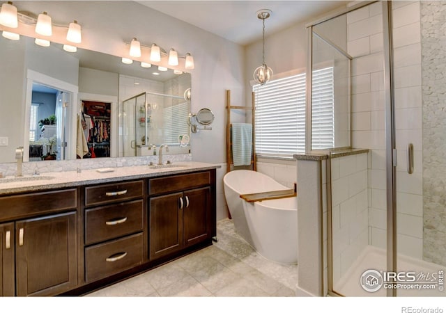 full bath with double vanity, a freestanding tub, a shower stall, and a sink