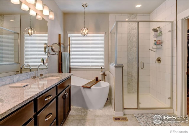 bathroom with tile patterned flooring, visible vents, a freestanding tub, vanity, and a stall shower
