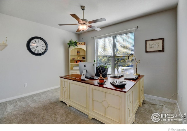home office featuring a ceiling fan, baseboards, and light carpet