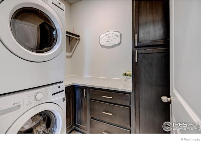 laundry area featuring cabinet space and stacked washing maching and dryer
