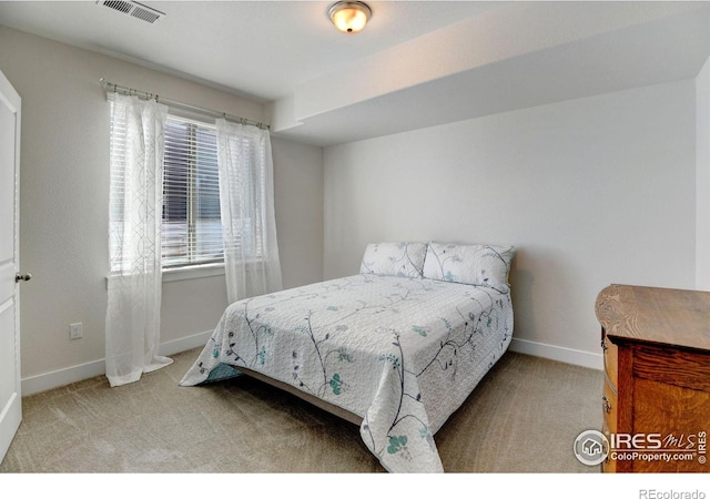 carpeted bedroom featuring baseboards and visible vents