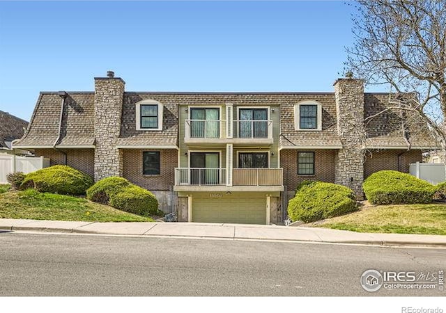 15503 E Wyoming Dr Unit G, Aurora, CO 80017 - view of front of house with a chimney, an attached garage, and mansard roof