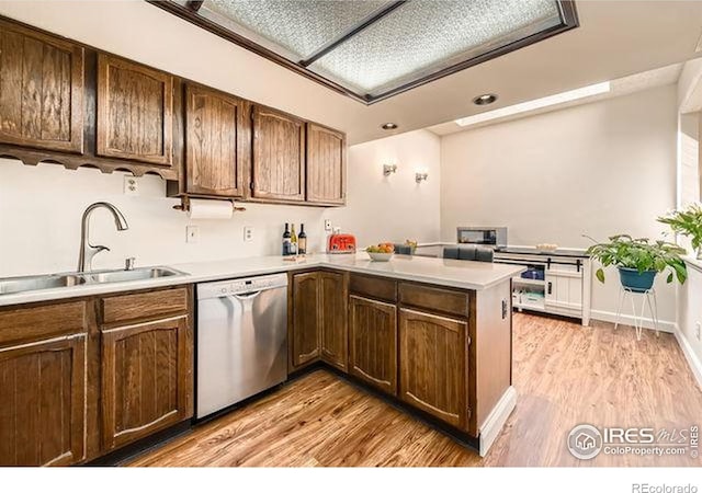 15503 E Wyoming Dr Unit G, Aurora, CO 80017 - kitchen featuring dishwasher, a sink, a peninsula, light countertops, and light wood-style flooring