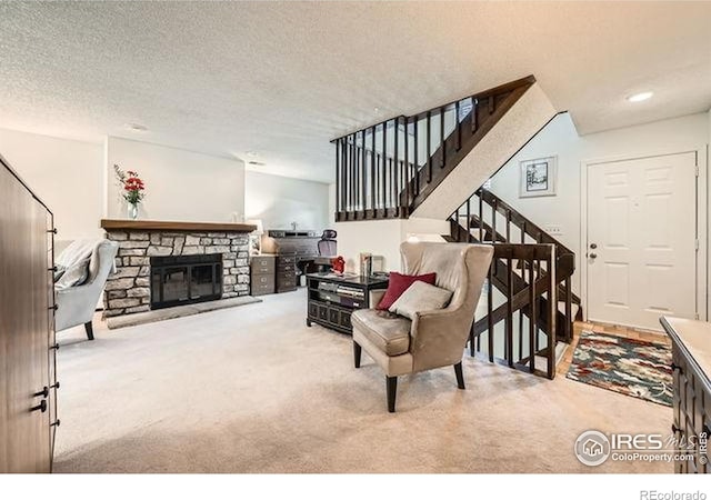15503 E Wyoming Dr Unit G, Aurora, CO 80017 - living area with carpet flooring, stairway, a stone fireplace, and a textured ceiling