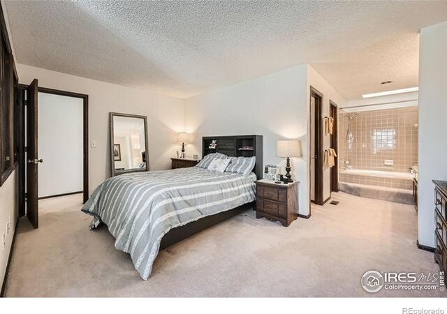 15503 E Wyoming Dr Unit G, Aurora, CO 80017 - bedroom featuring carpet, a textured ceiling, and connected bathroom
