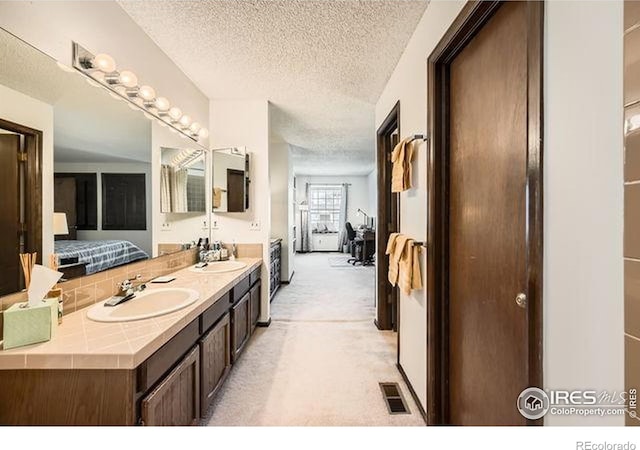 15503 E Wyoming Dr Unit G, Aurora, CO 80017 - bathroom with a textured ceiling, double vanity, and ensuite bathroom