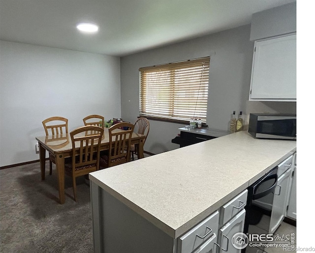 425 Stanford St, Brush, CO 80723 - kitchen featuring stainless steel microwave, a peninsula, light countertops, black dishwasher, and dark carpet