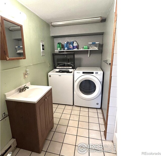 425 Stanford St, Brush, CO 80723 - washroom featuring a sink, separate washer and dryer, and light tile patterned floors