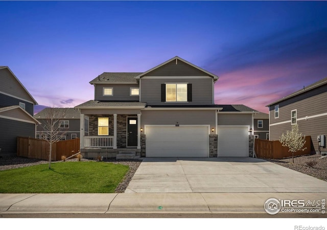 3759 Catmint St, Wellington, CO 80549 - view of front of home with fence, driveway, stone siding, a porch, and a yard