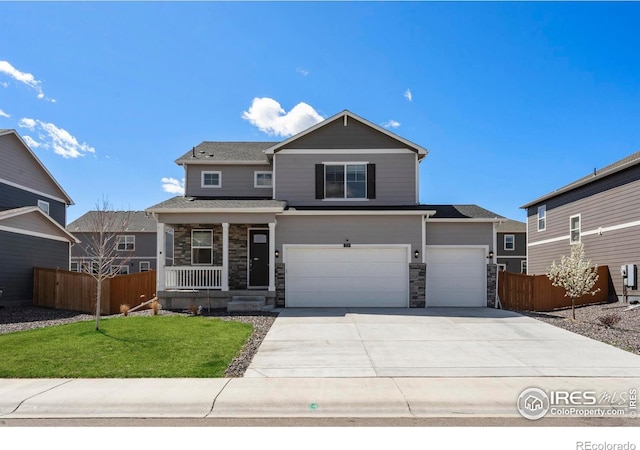 3759 Catmint St, Wellington, CO 80549 - view of front facade featuring covered porch, driveway, a front yard, fence, and stone siding