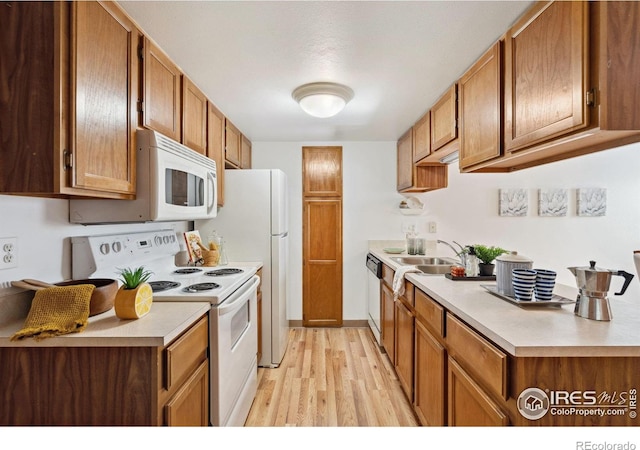 4560 Larkbunting Dr Unit 2B, Fort Collins, CO 80526 - kitchen featuring white appliances, light wood-style floors, light countertops, and a sink