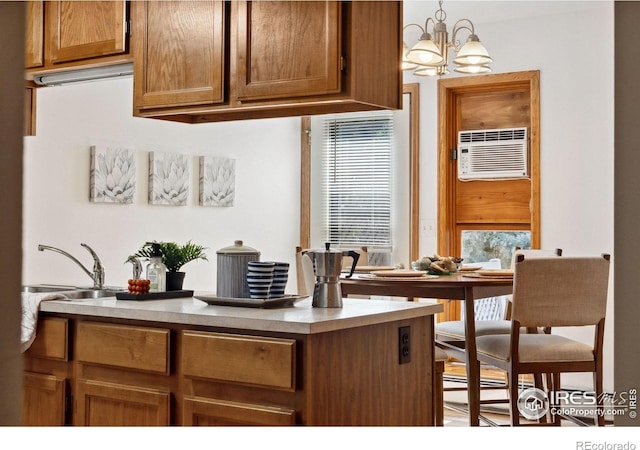 4560 Larkbunting Dr Unit 2B, Fort Collins, CO 80526 - kitchen featuring a sink, a wall unit AC, a chandelier, hanging light fixtures, and brown cabinets