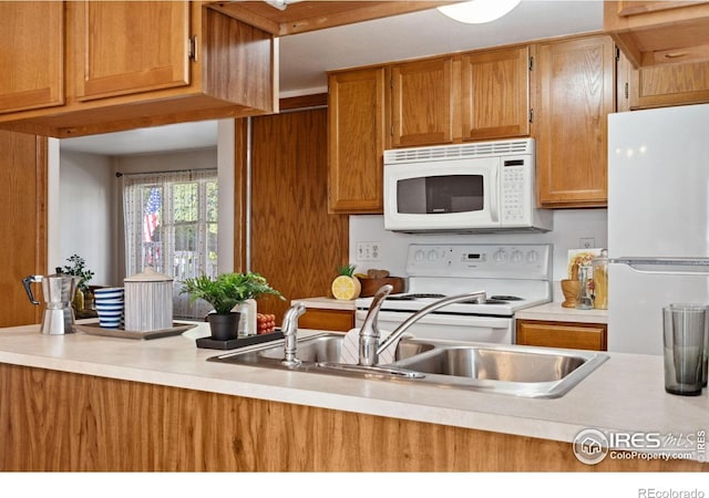 4560 Larkbunting Dr Unit 2B, Fort Collins, CO 80526 - kitchen featuring white appliances, light countertops, a sink, and brown cabinetry