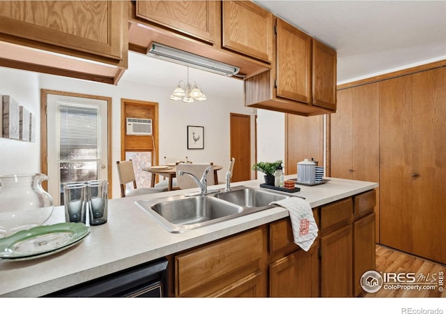 4560 Larkbunting Dr Unit 2B, Fort Collins, CO 80526 - kitchen featuring a sink, light countertops, brown cabinetry, a chandelier, and light wood-style floors