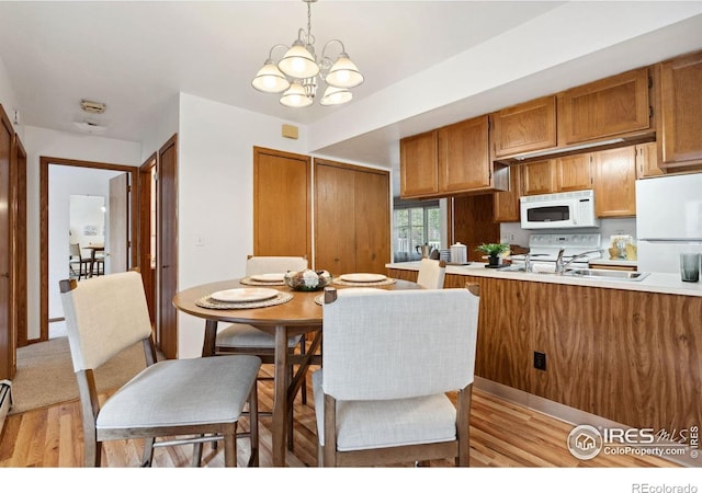 4560 Larkbunting Dr Unit 2B, Fort Collins, CO 80526 - dining area featuring light wood finished floors, a chandelier, and a baseboard radiator